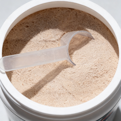 Open container of powder with a scoop inside, on a light gray background